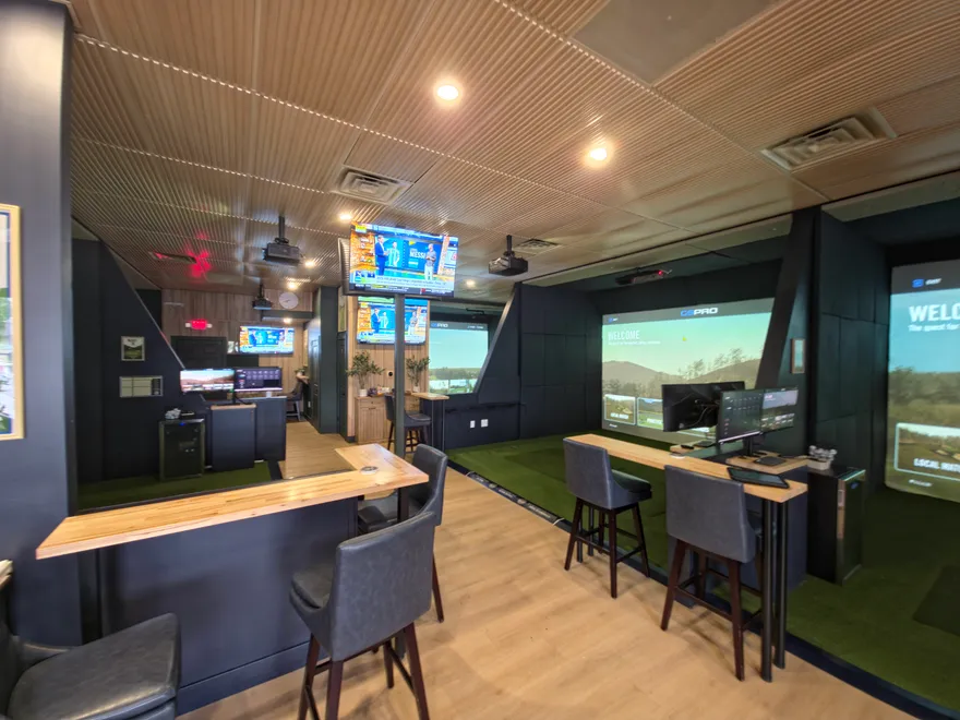 All Seasons Indoor Golf Club showroom floor in Kansas City with multiple simulator bays and bar seating