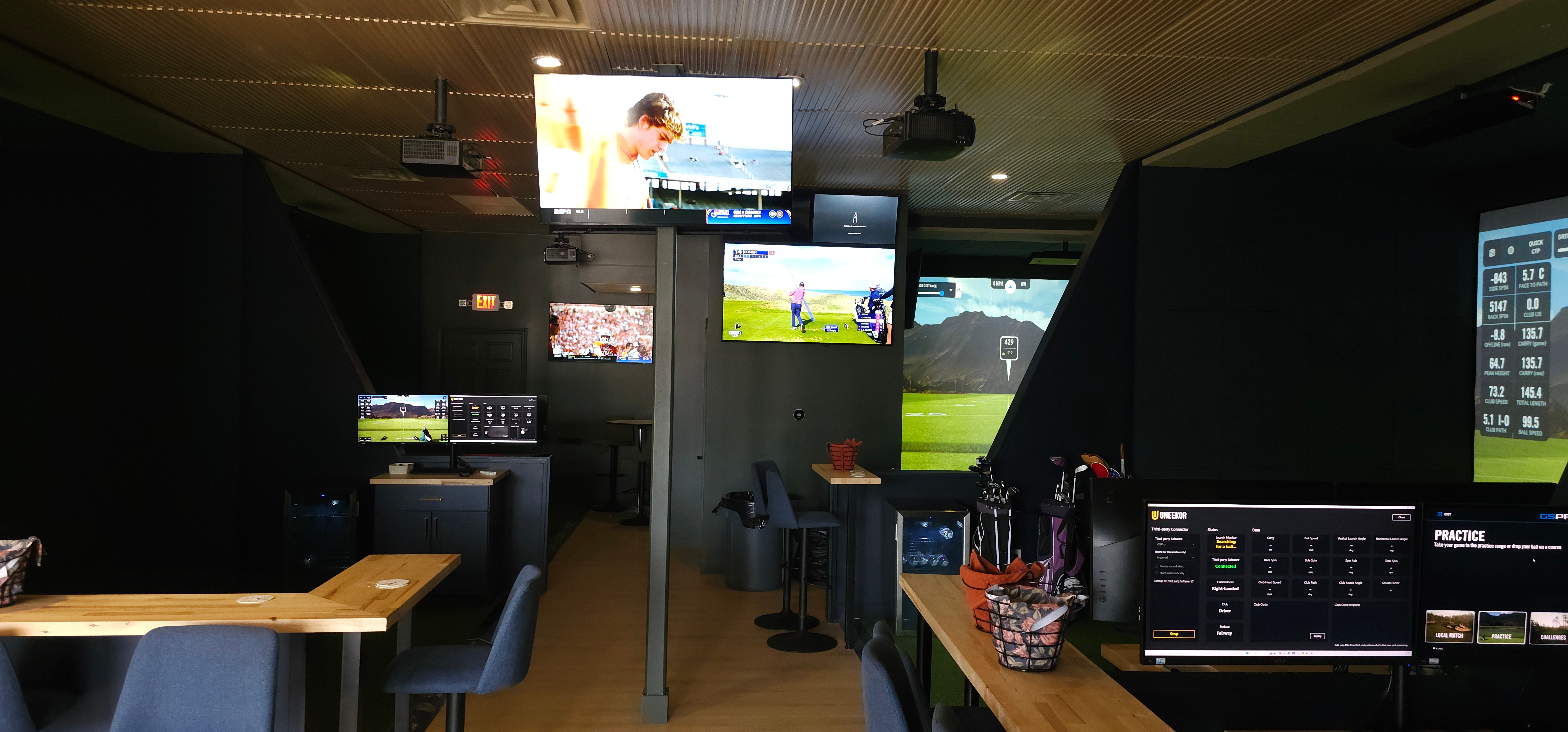 Multiple simulator bays and lounge seating on the public floor at All Seasons Indoor Golf Club