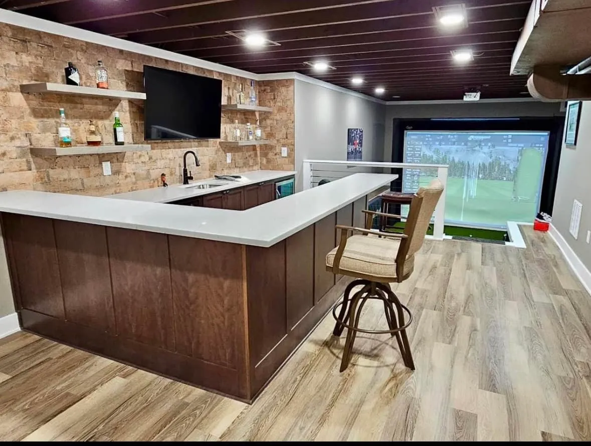 Finished basement bar beside a golf simulator bay, built for a Kansas City, Missouri home