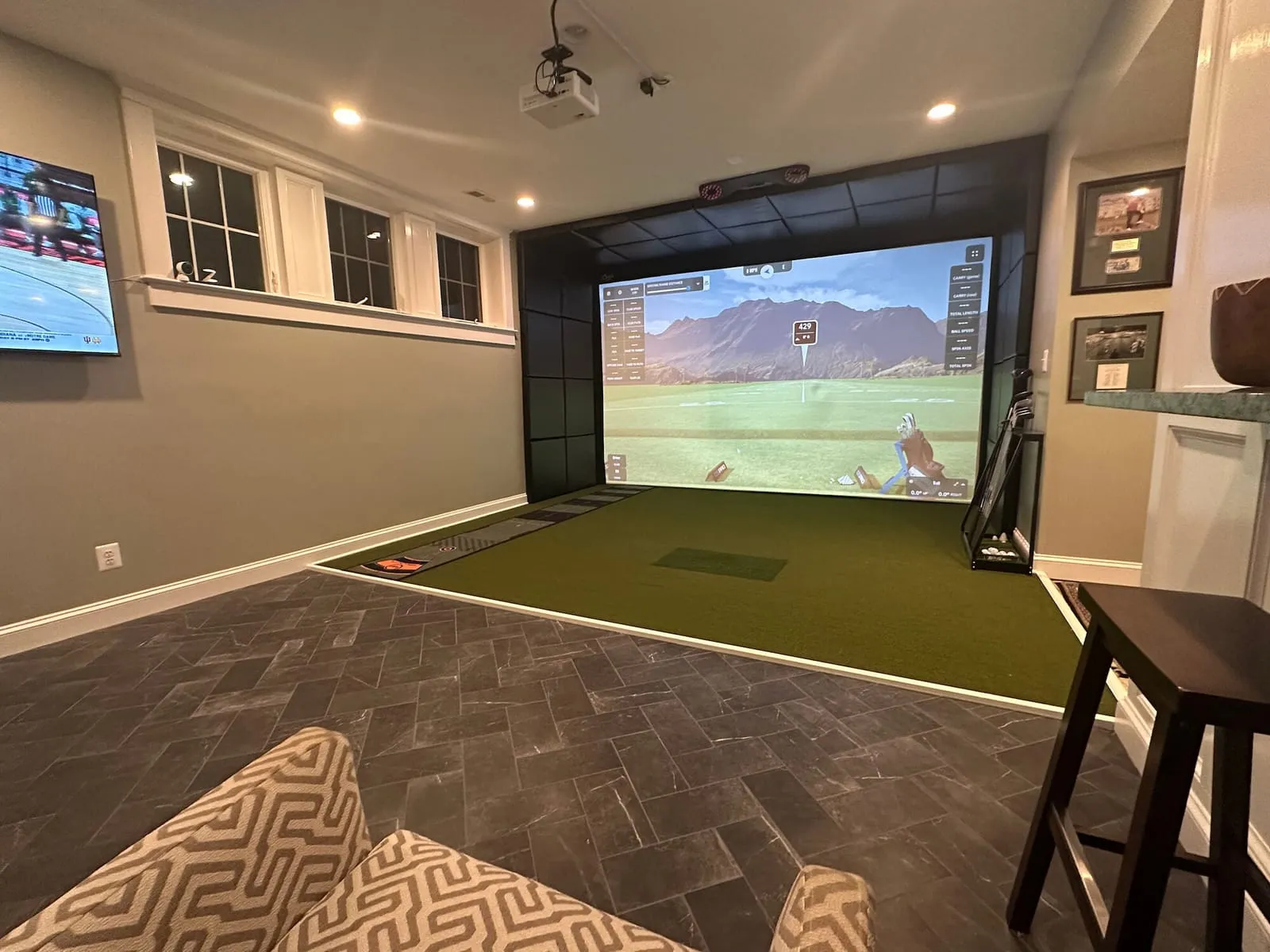 Finished basement golf simulator room with a TV lounge, built for a Columbia, Missouri home