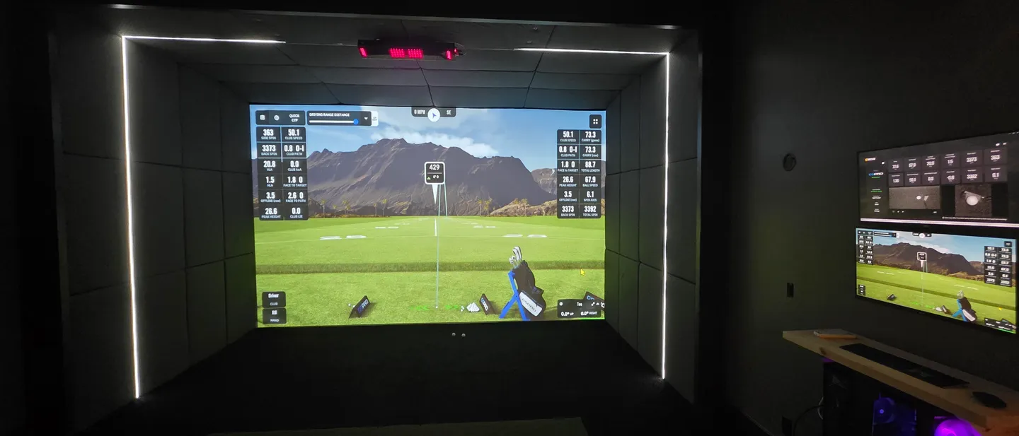 A golf course projected on an impact screen in a finished All Seasons sim room