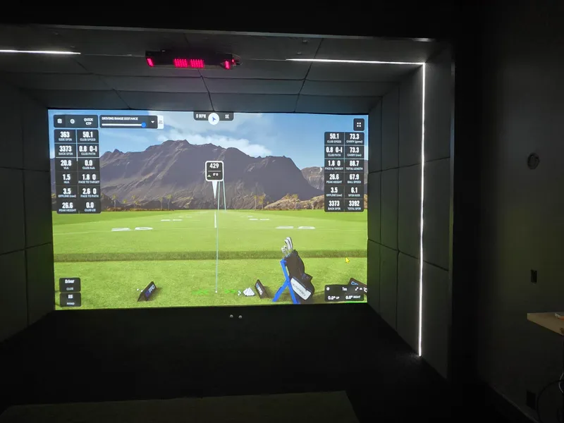 Finished Kansas City golf simulator room with an LED-lit impact screen and shot data