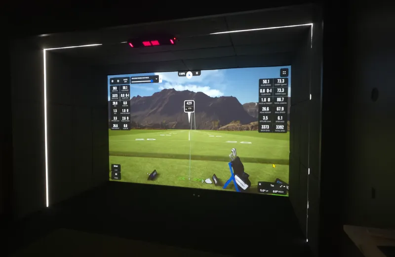 Finished Kansas City golf simulator room with an LED-lit impact screen and shot data