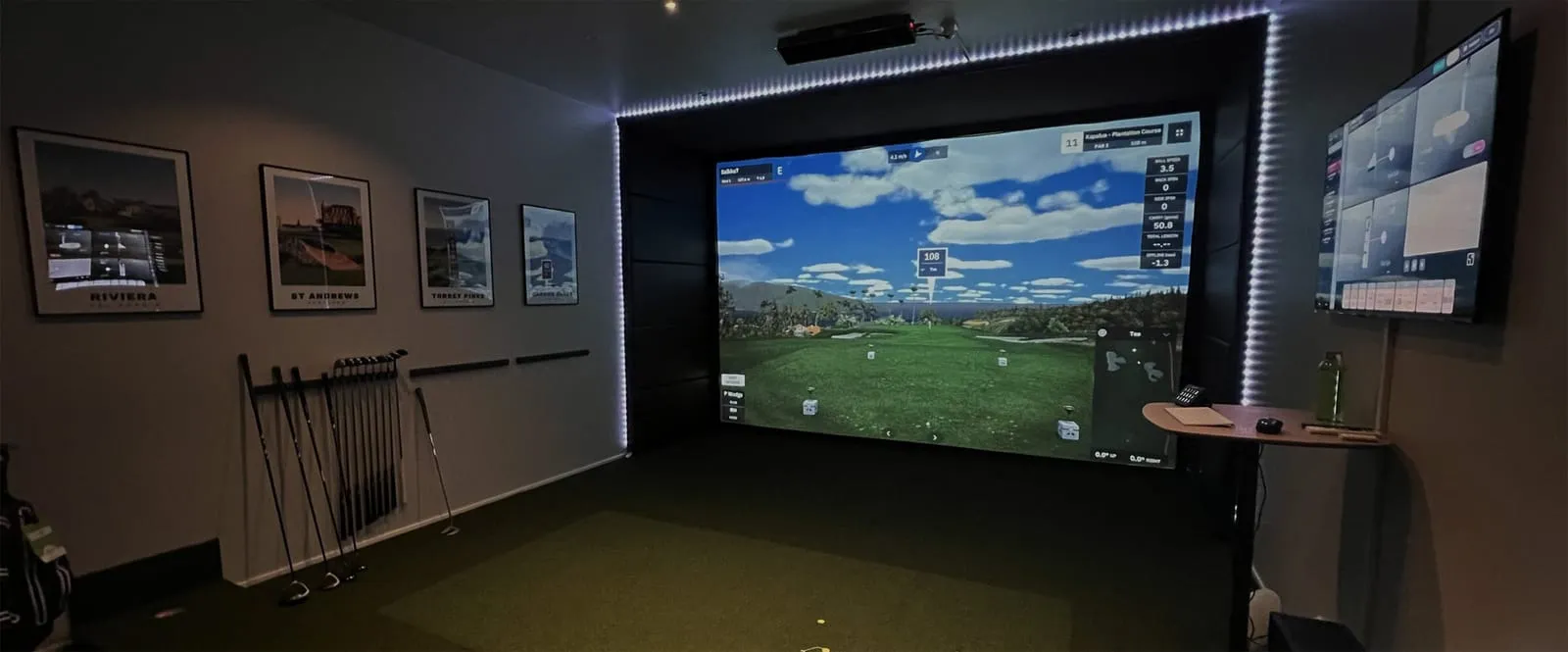 Golf simulator room lined with course posters — see builds like it at the All Seasons Kansas City showroom