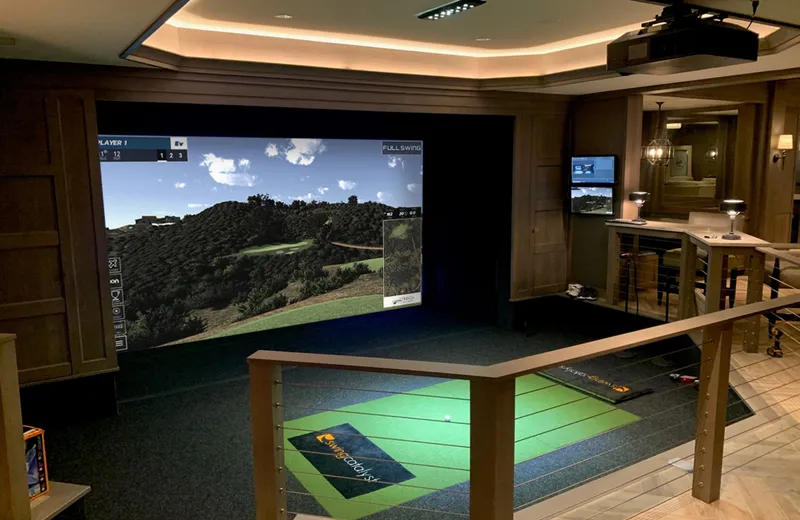 Luxury wood-paneled golf simulator room with the course on screen in a Kansas City home
