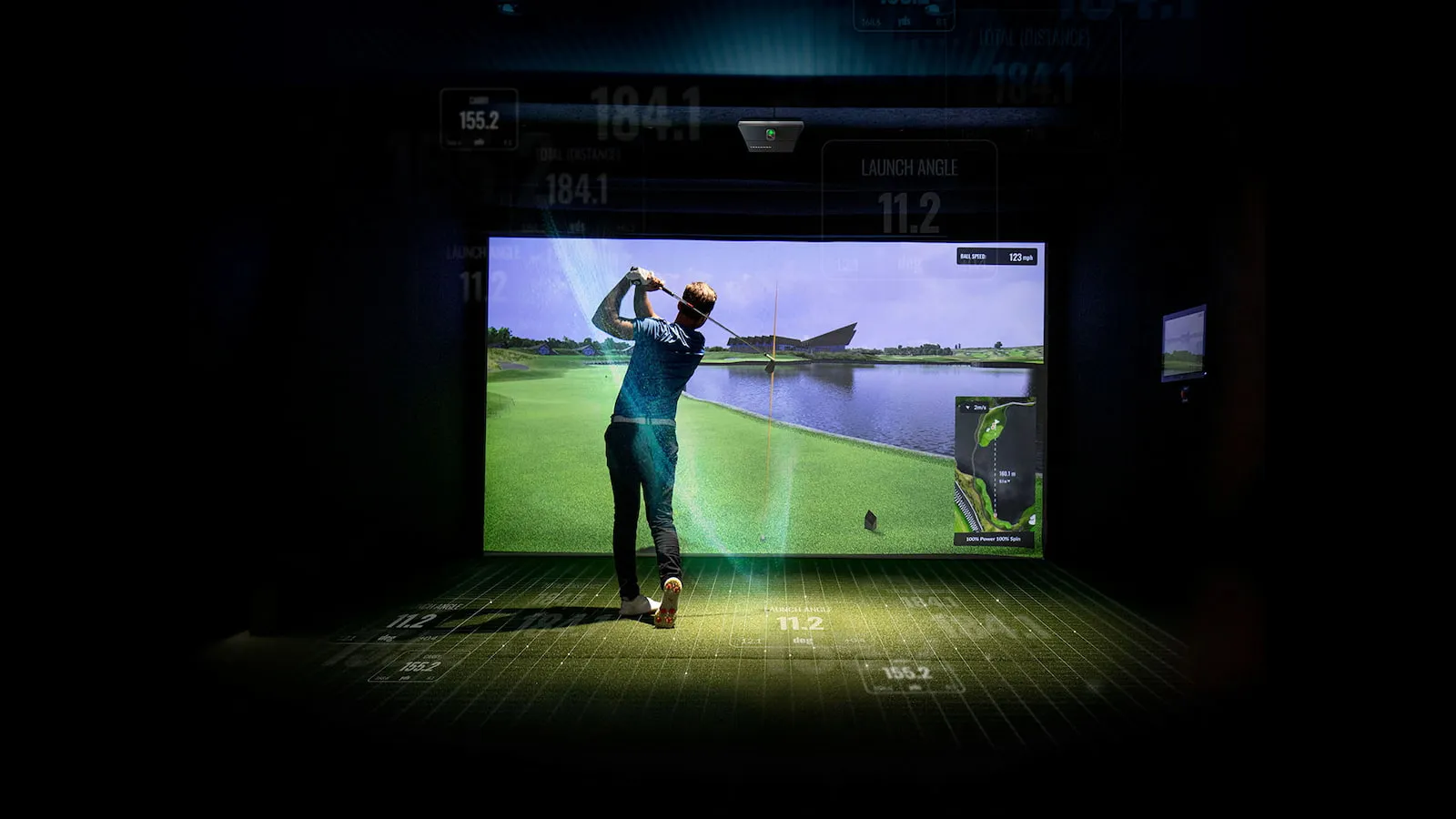 Golfer mid-swing in a finished golf simulator, built for Four Seasons, Lake of the Ozarks homes