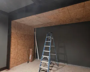 Golf simulator room mid-build with OSB-sheathed walls and ceiling