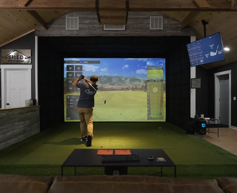 Finished Kansas City golf simulator room showing the full equipment stack — overhead launch monitor, projector, and impact screen
